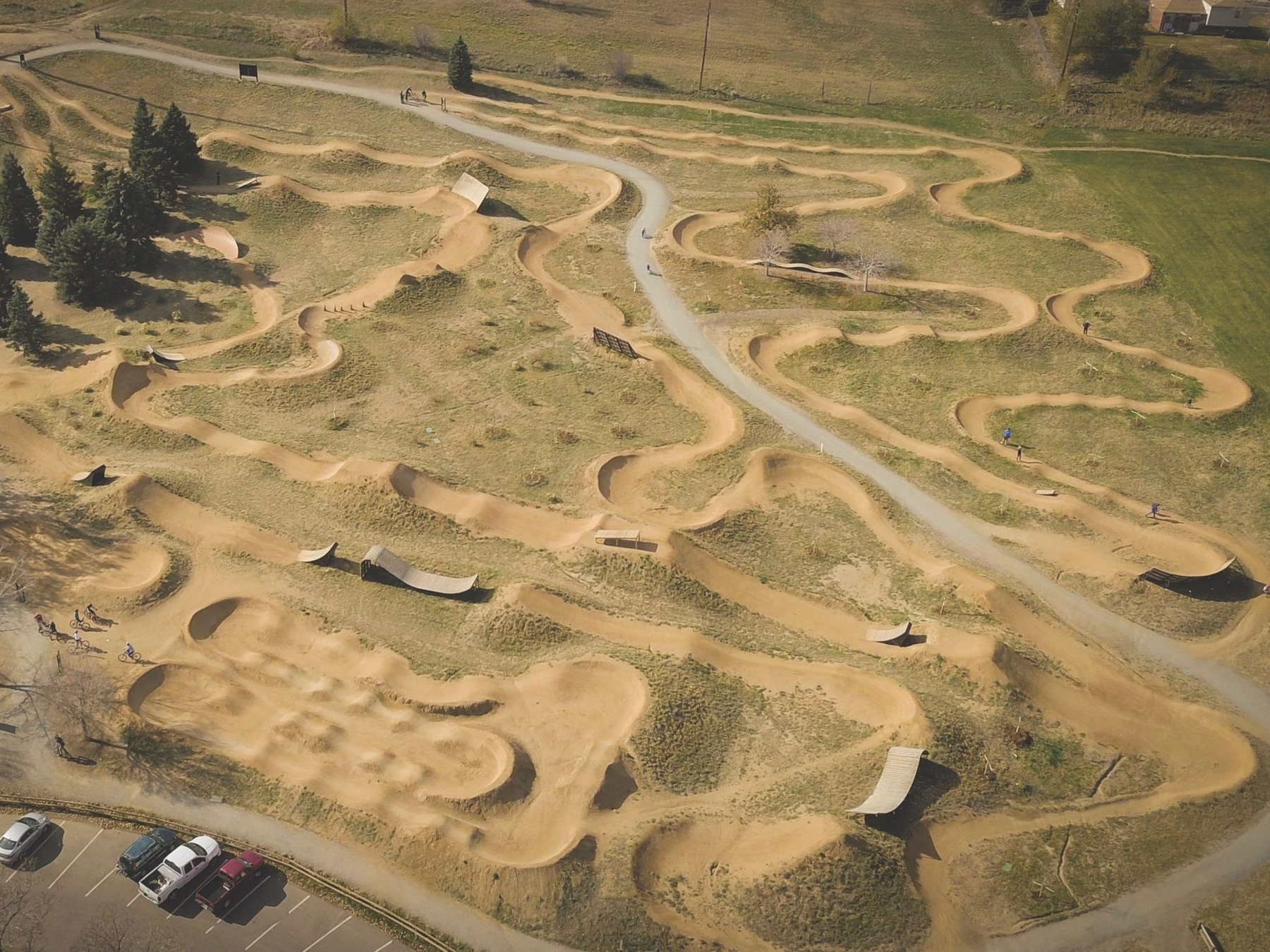 Aerial photograph of a dirt bike skills park with pump tracks, berms and jump lines — a reference image of a comparable facility, not the Pine Bluff site